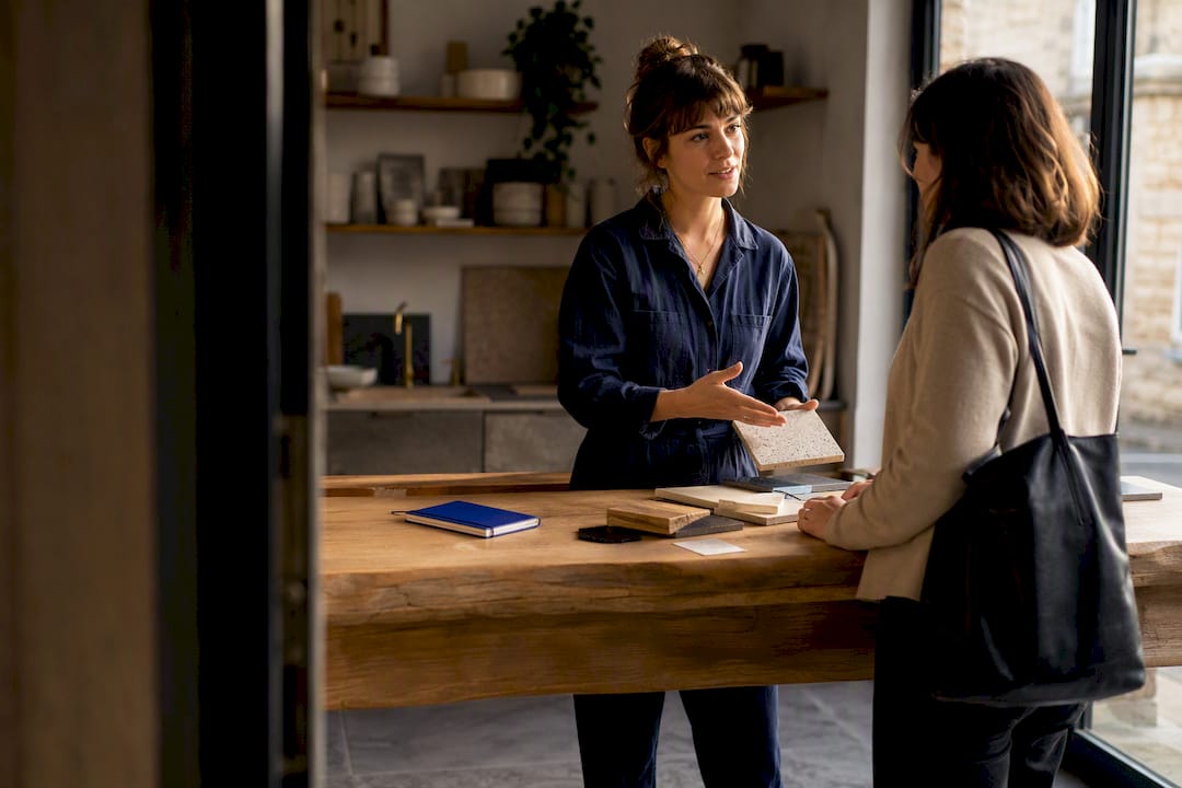 Femme entrepreneure en discussion avec une cliente dans son atelier